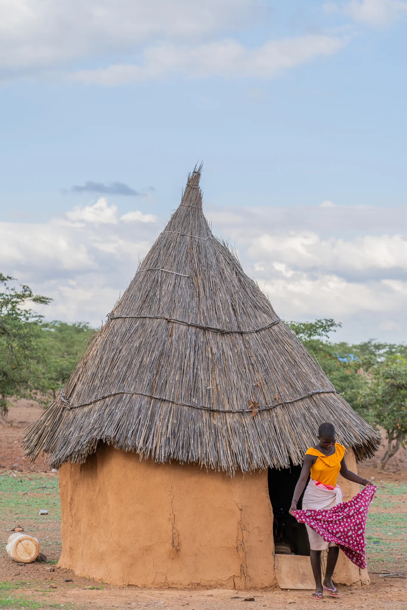 Himba woman outside her hut at dusk, Namibia