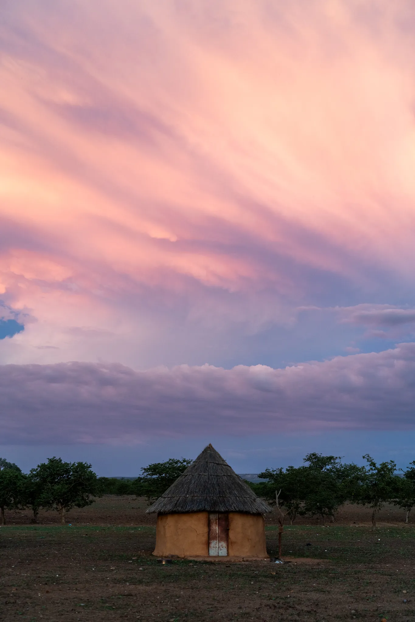 Thatched home under a pink sunset sky, Namibia