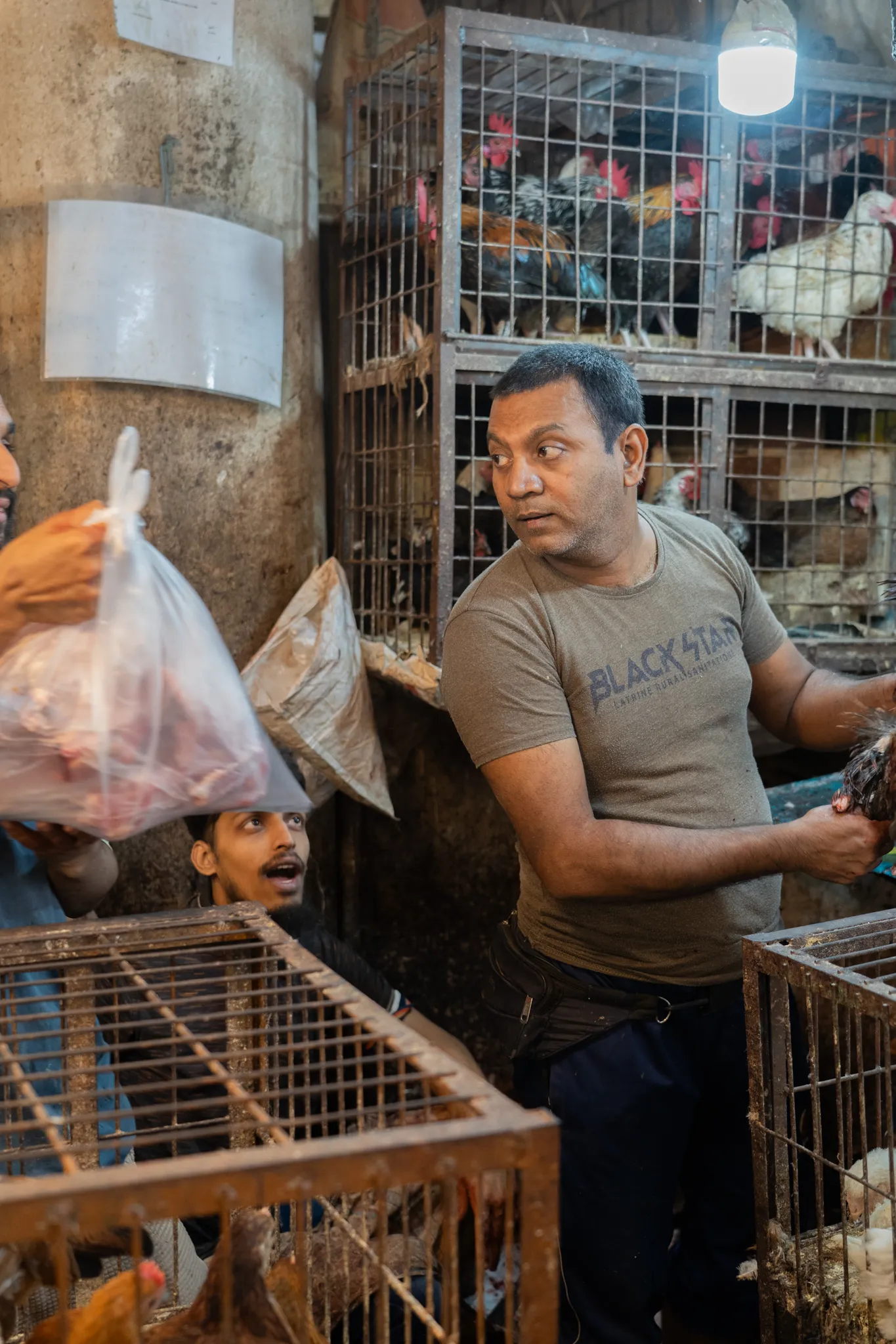 A vendor turns to answer a question mid-sale, Bangladesh