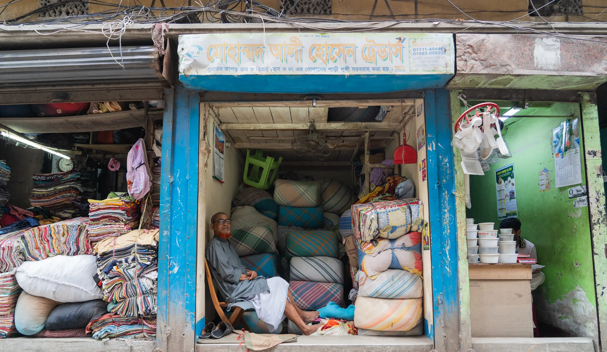 Bedding seller resting in his shopfront, Bangladesh