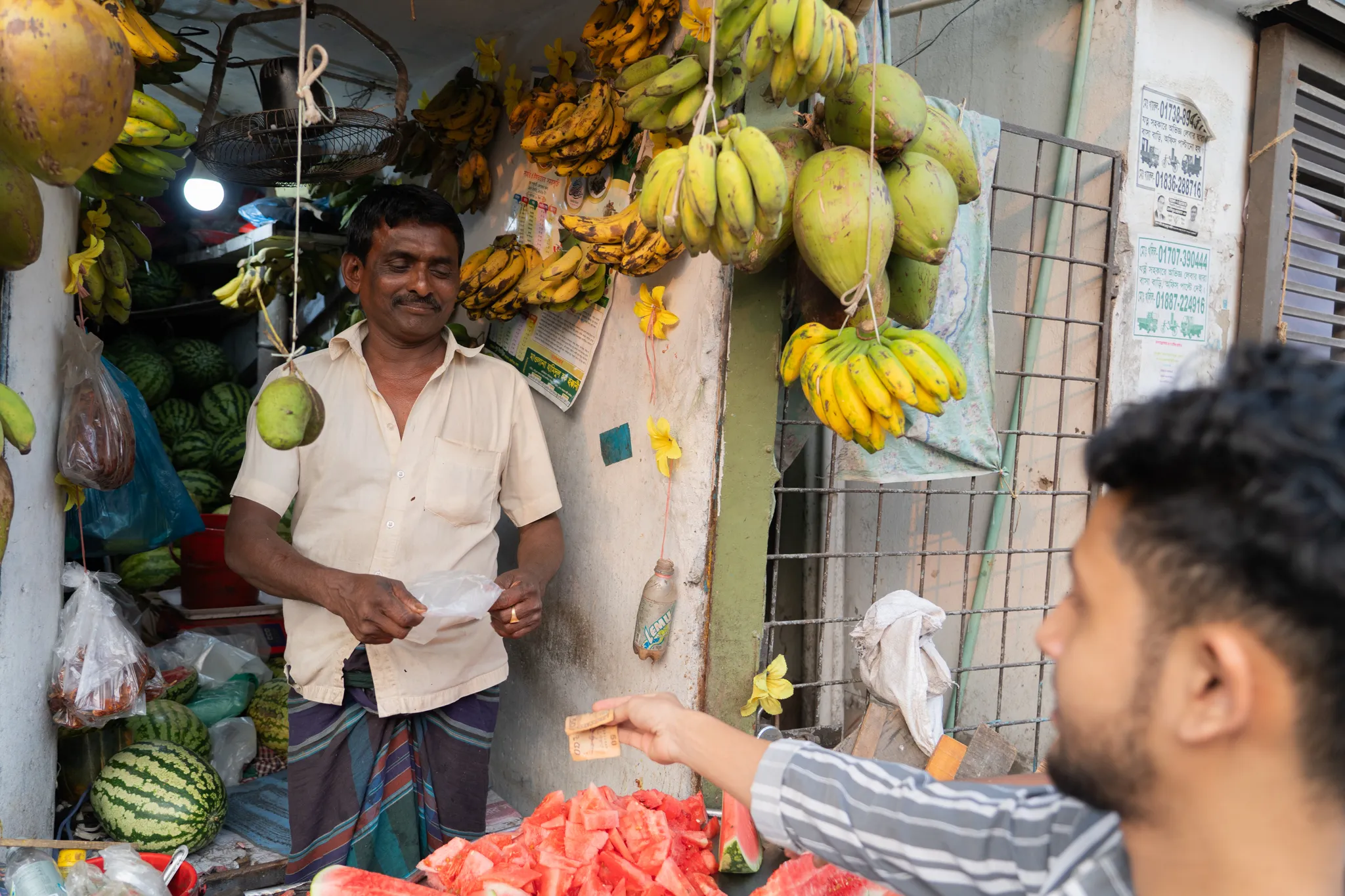 Watermelon vendor making change, Bangladesh