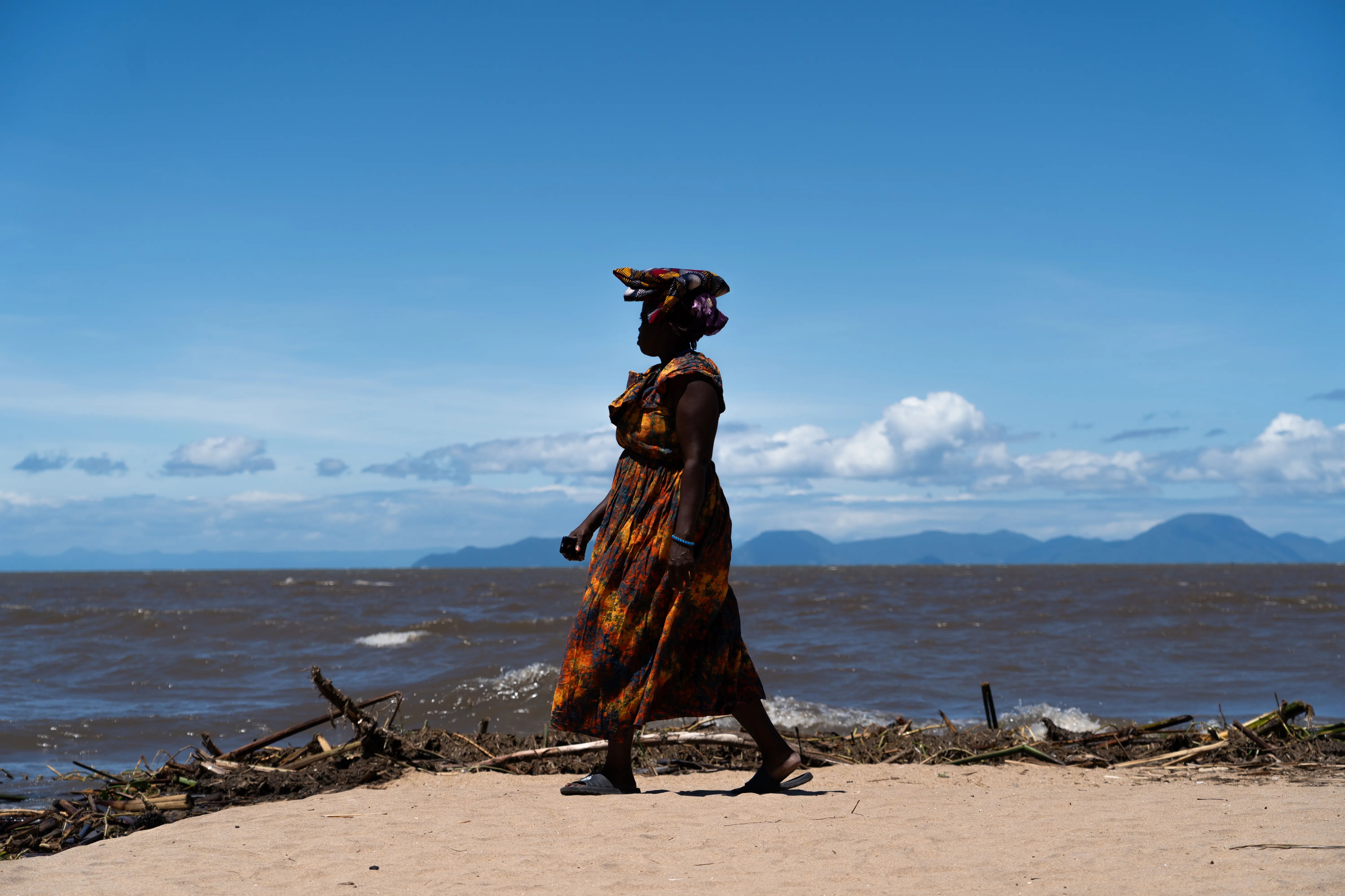 Woman walking the shore of Lake Malawi, Malawi