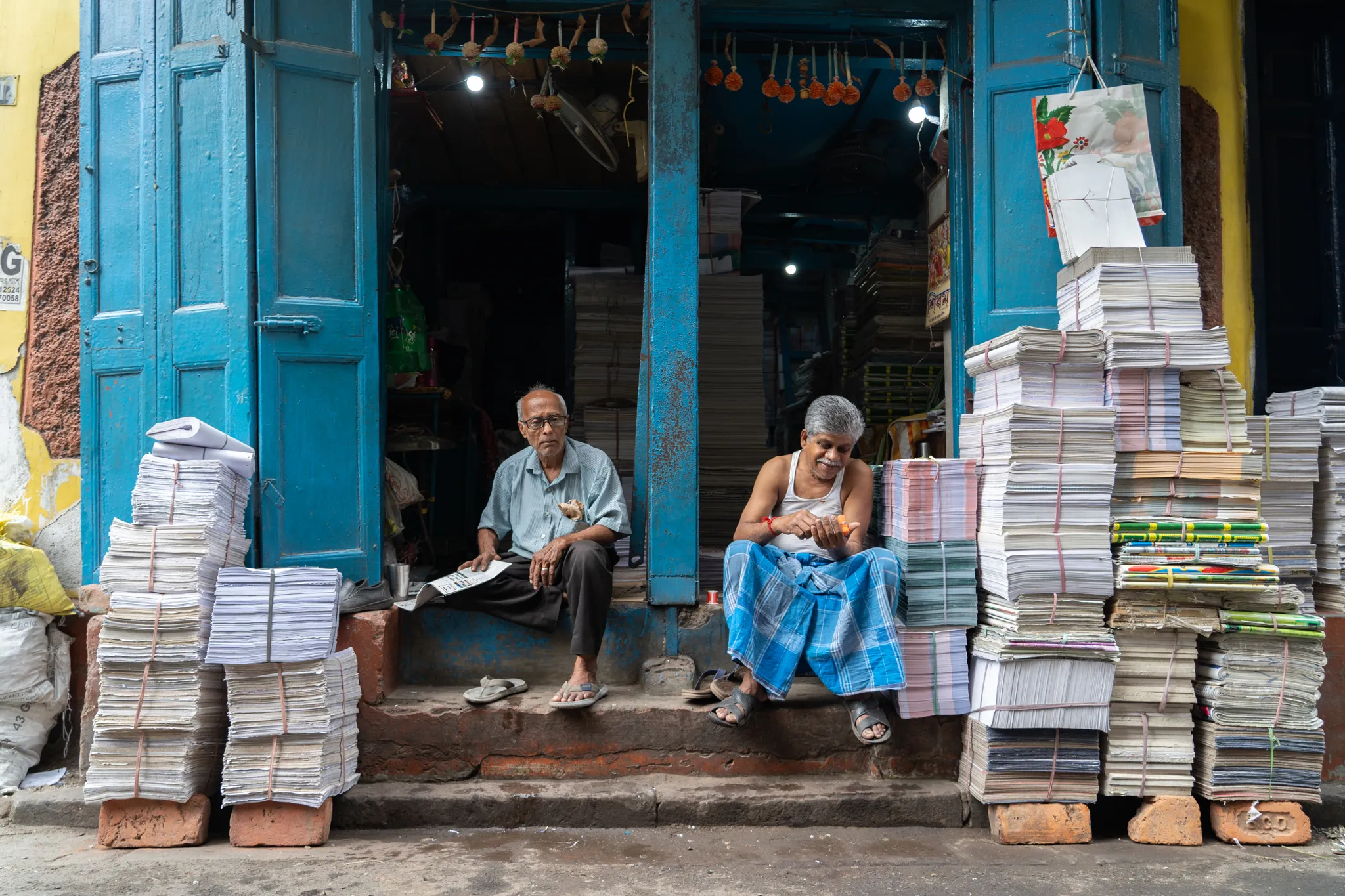 Paper sellers pause on the shop steps in Calcutta, India