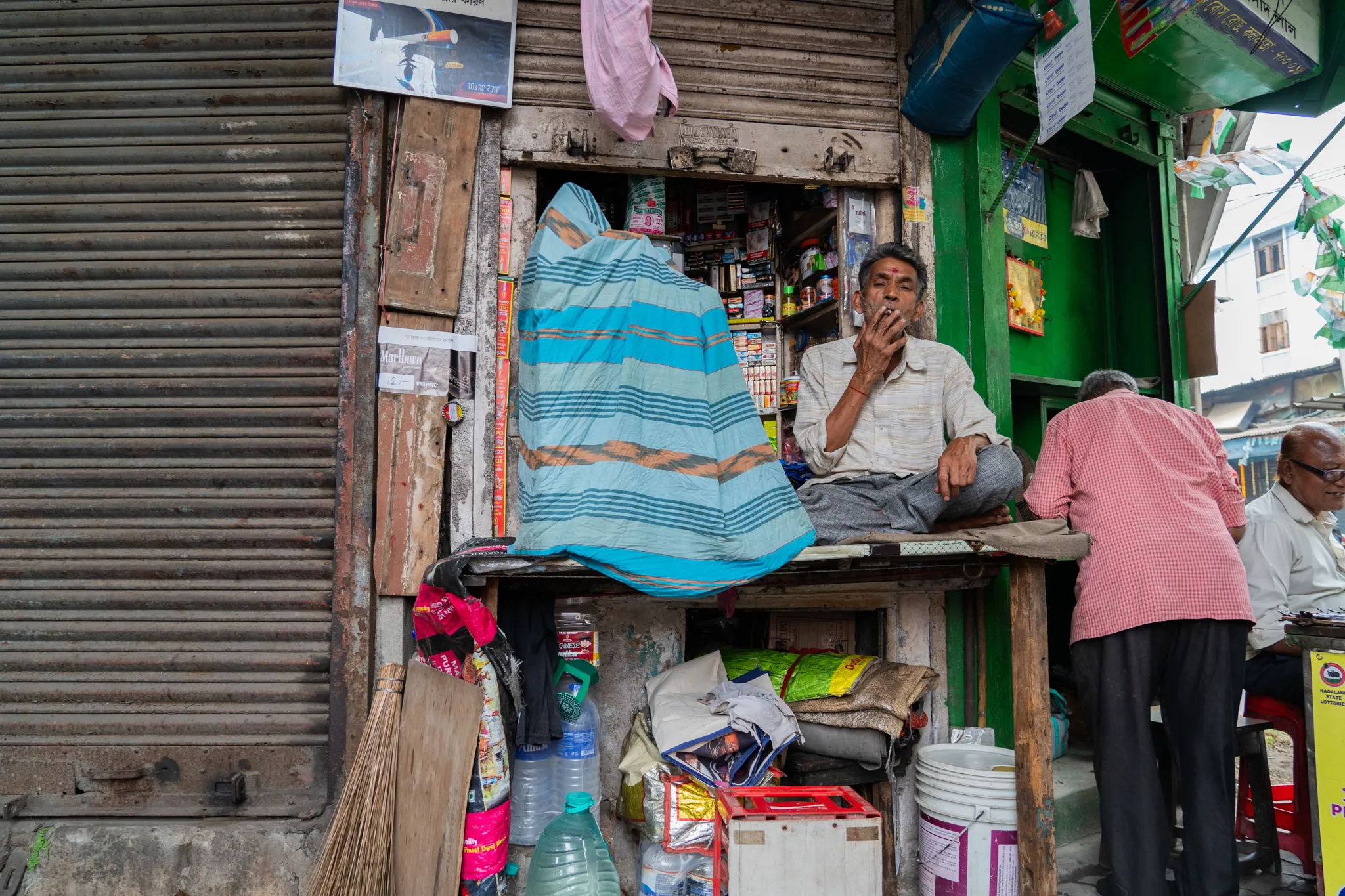 A smoke break at the corner shop in Calcutta, India
