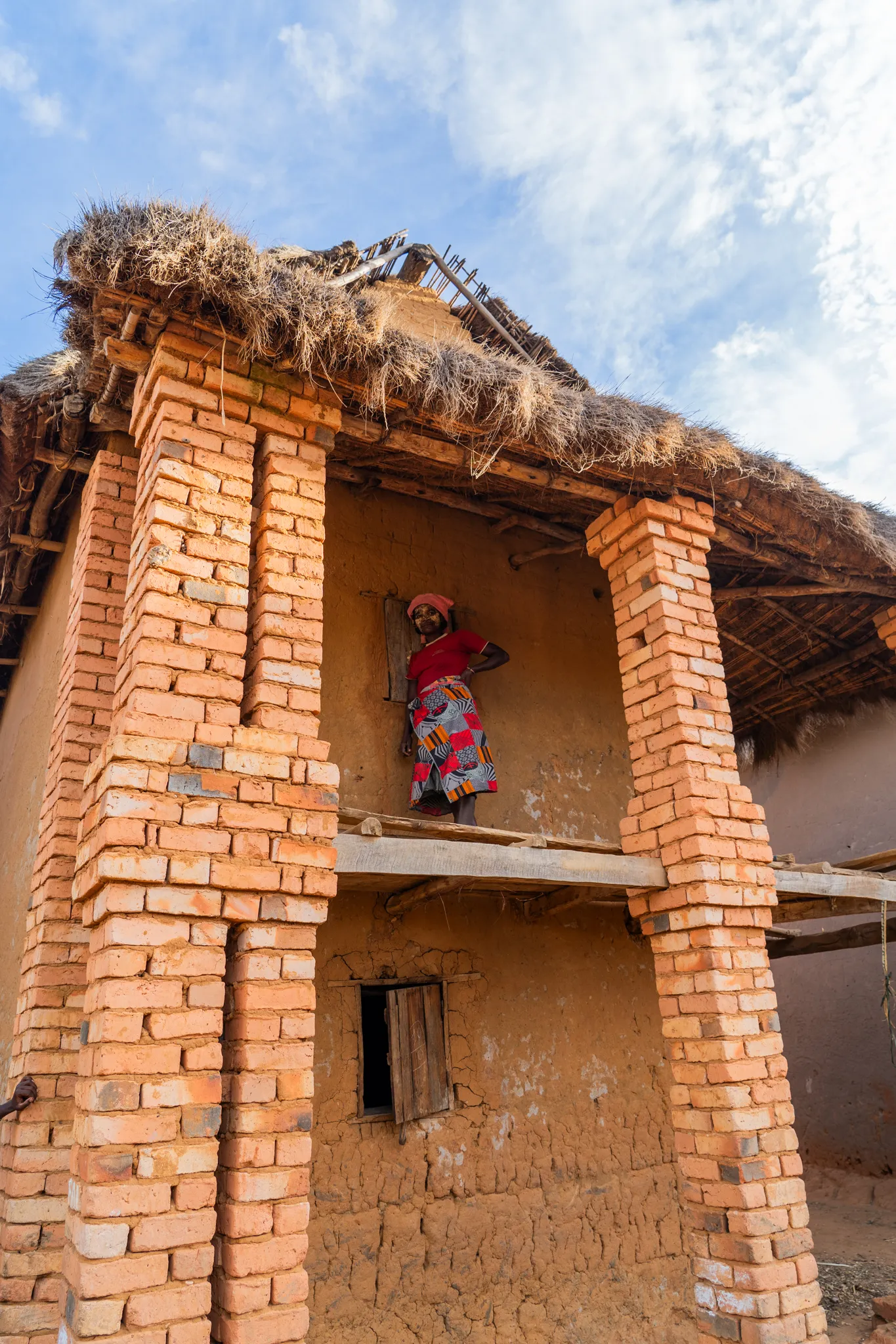 Woman on the balcony of a brick house in southern, Madagascar