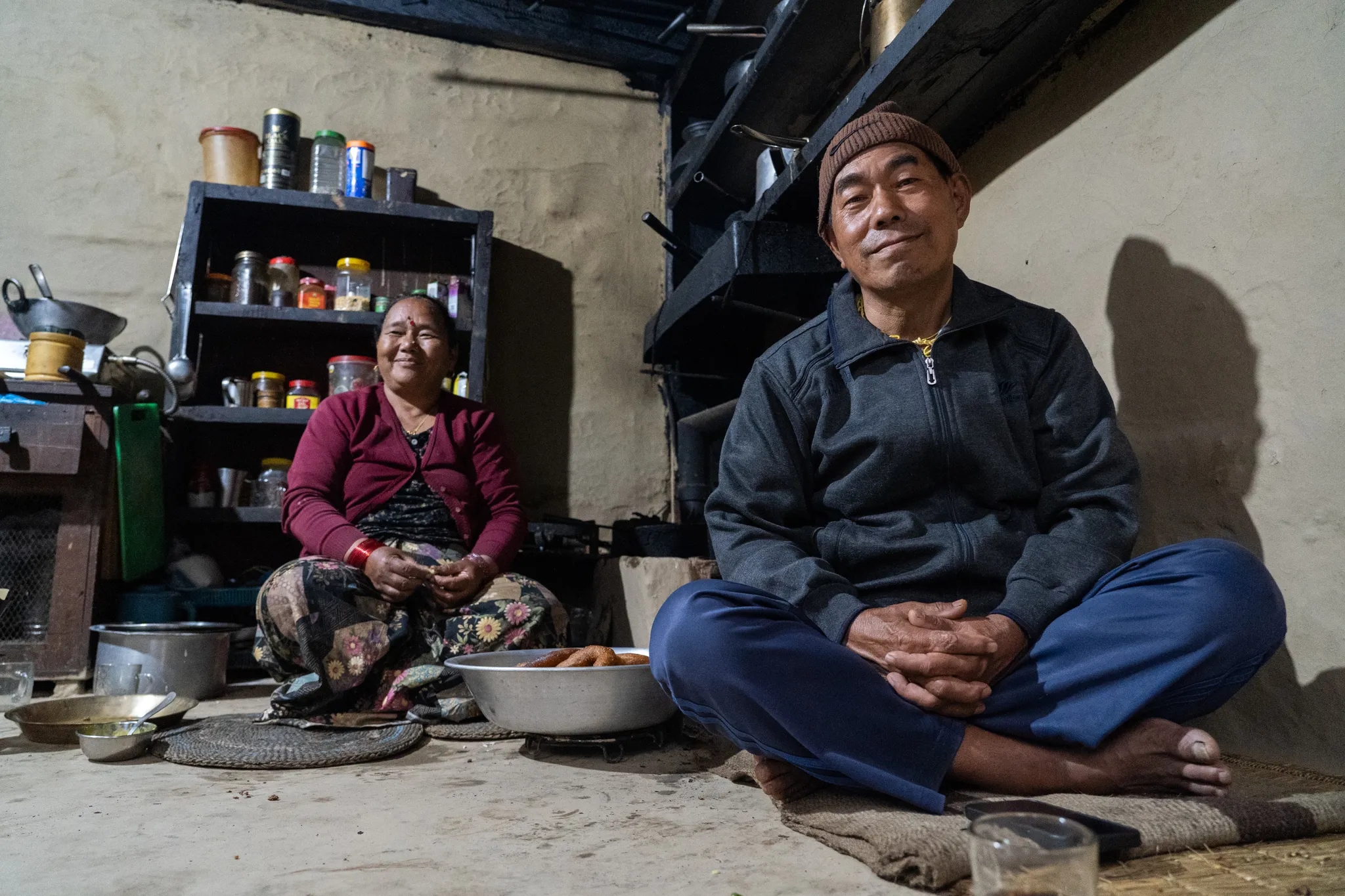 Portrait of a couple by their kitchen shelves, Nepal