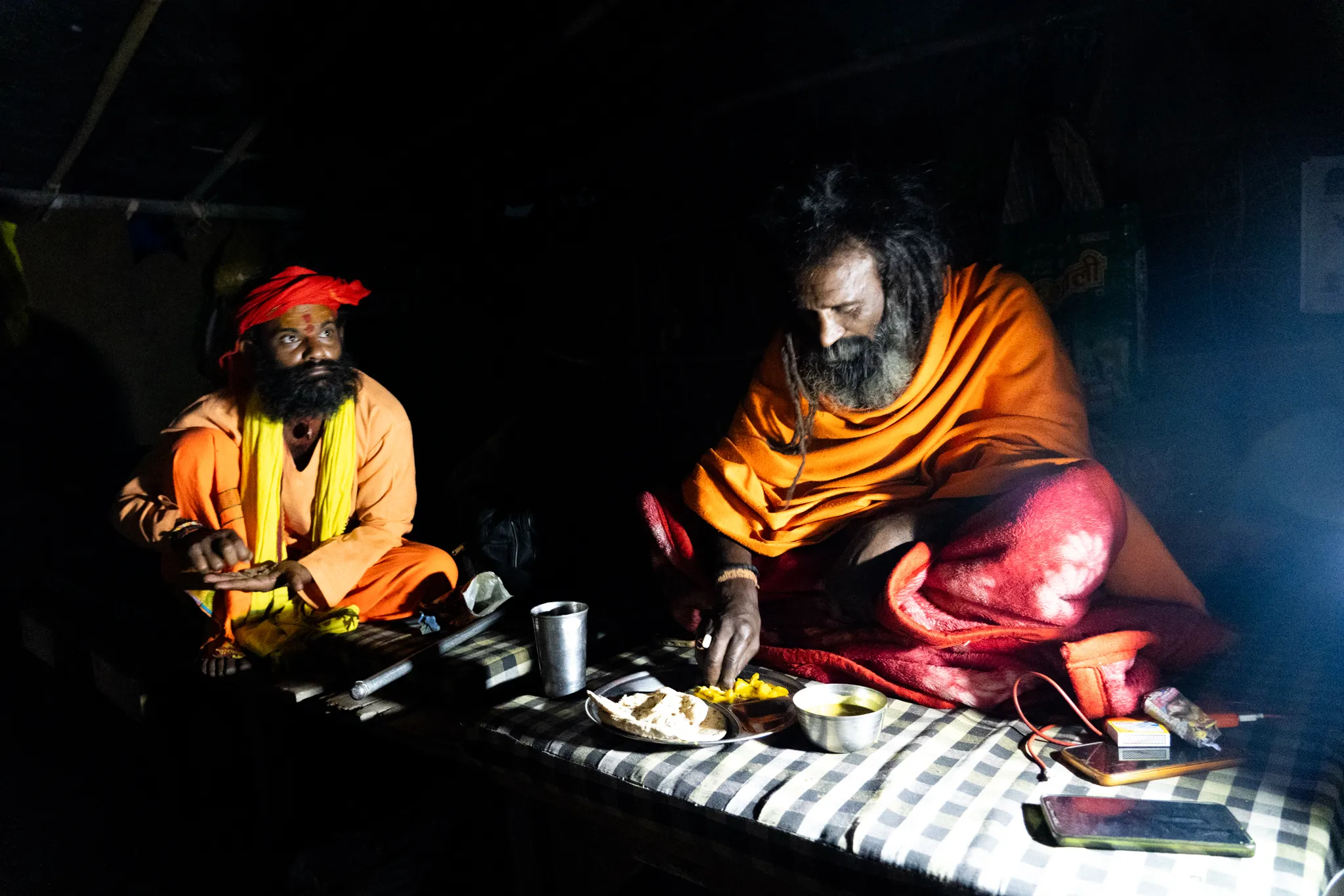 Sadhus sharing a meal by lamplight near Rishikesh, India