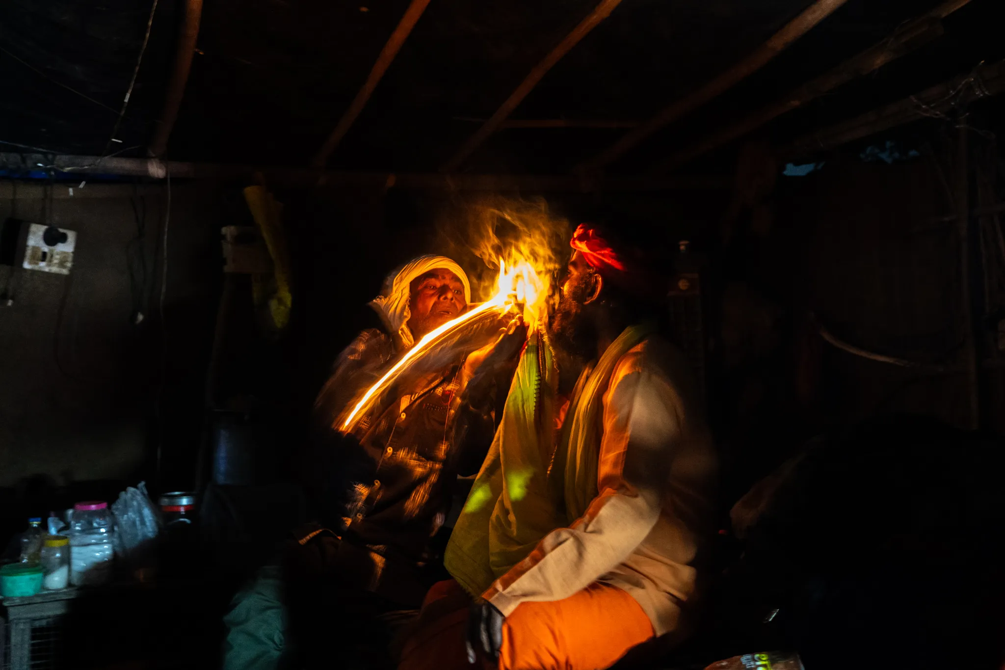 Lighting a chillum with a match and throwing it as the photo is taken near Rishikesh, India