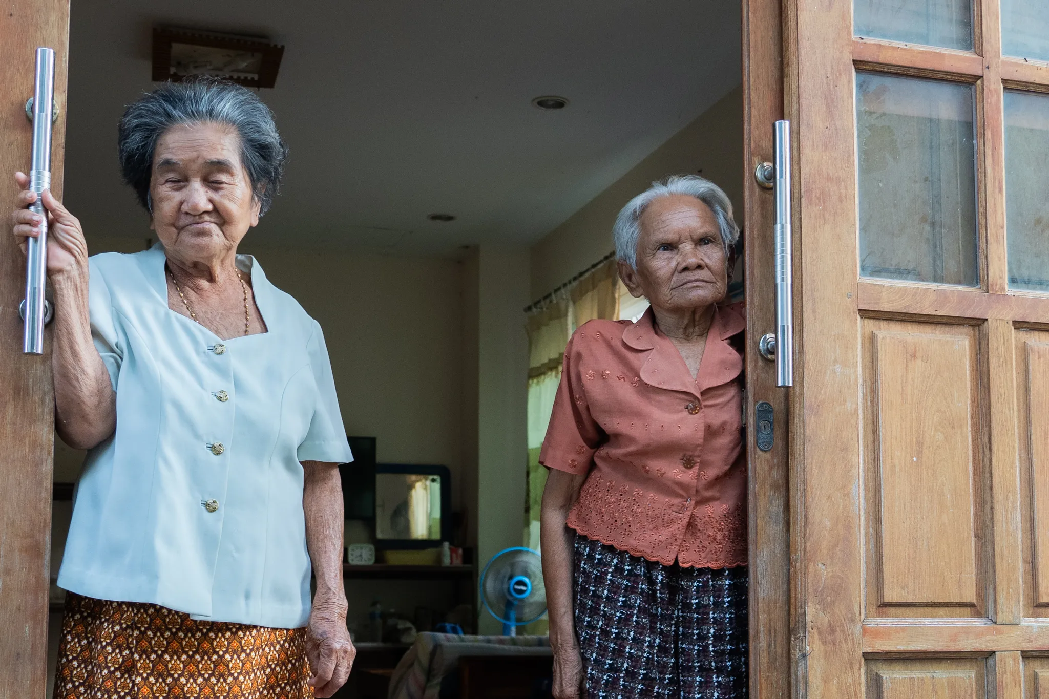 Two elderly women standing in a doorway, Thailand