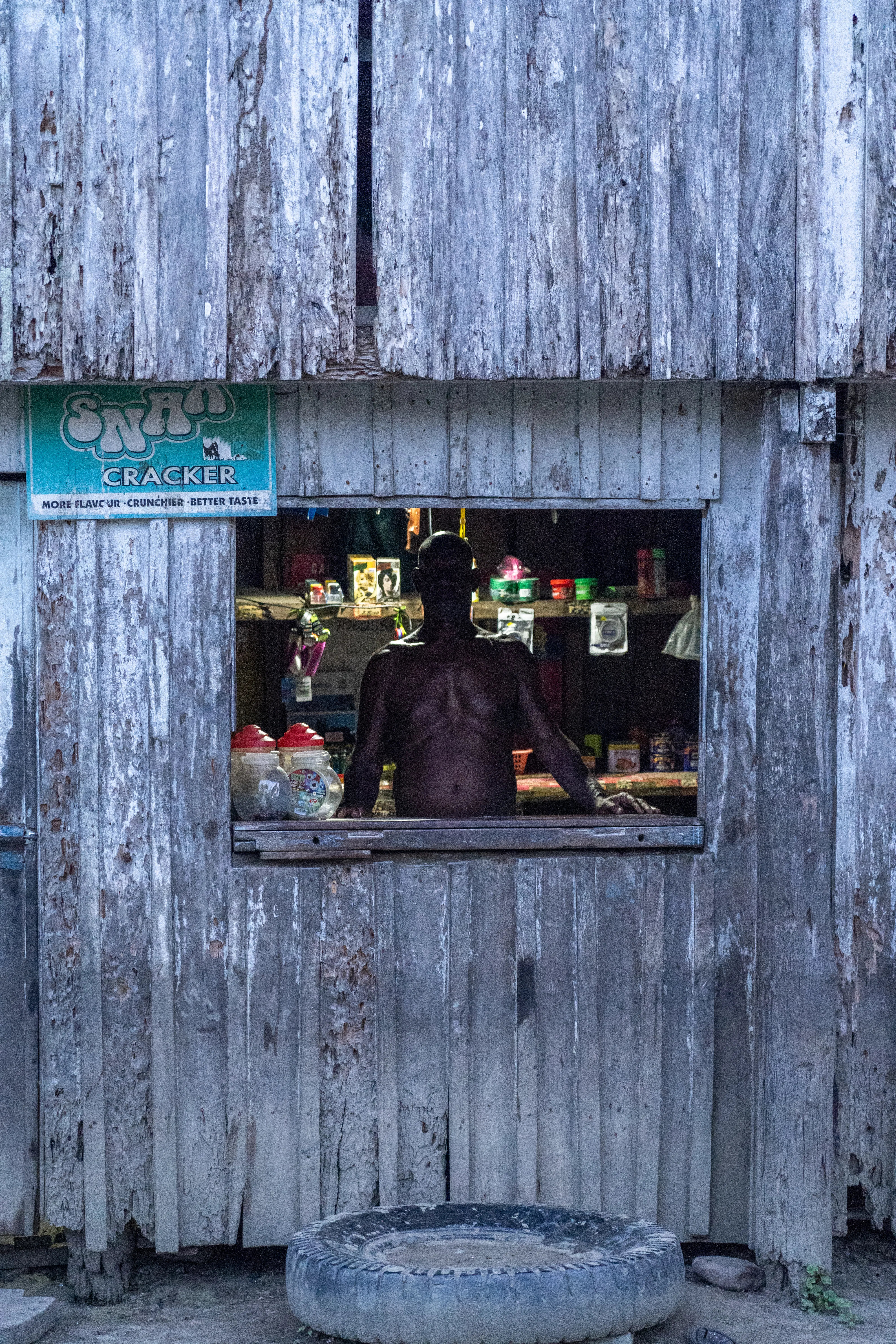 Man at a village trade store window, Papua New Guinea