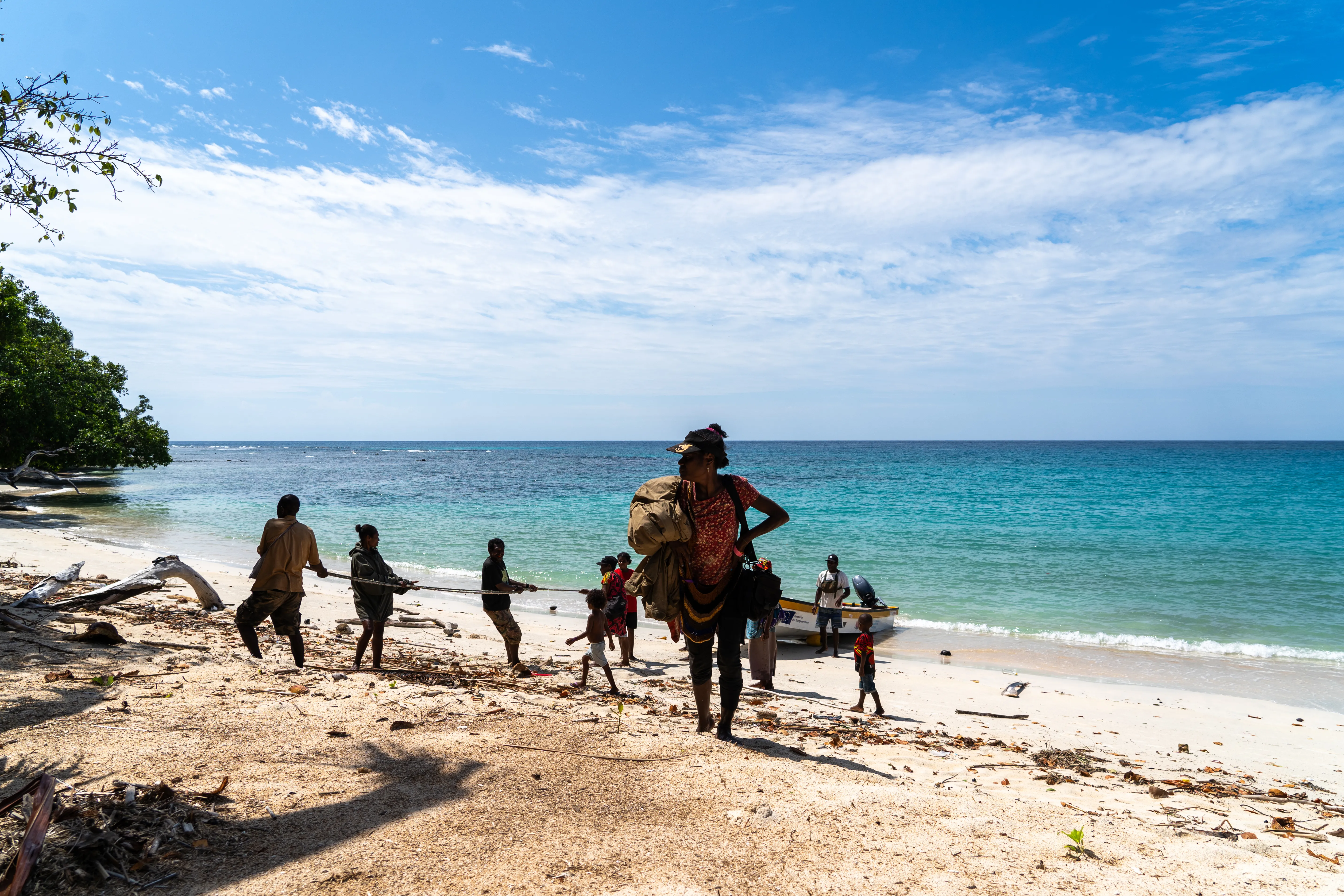 Villagers pull a boat ashore together, Papua New Guinea