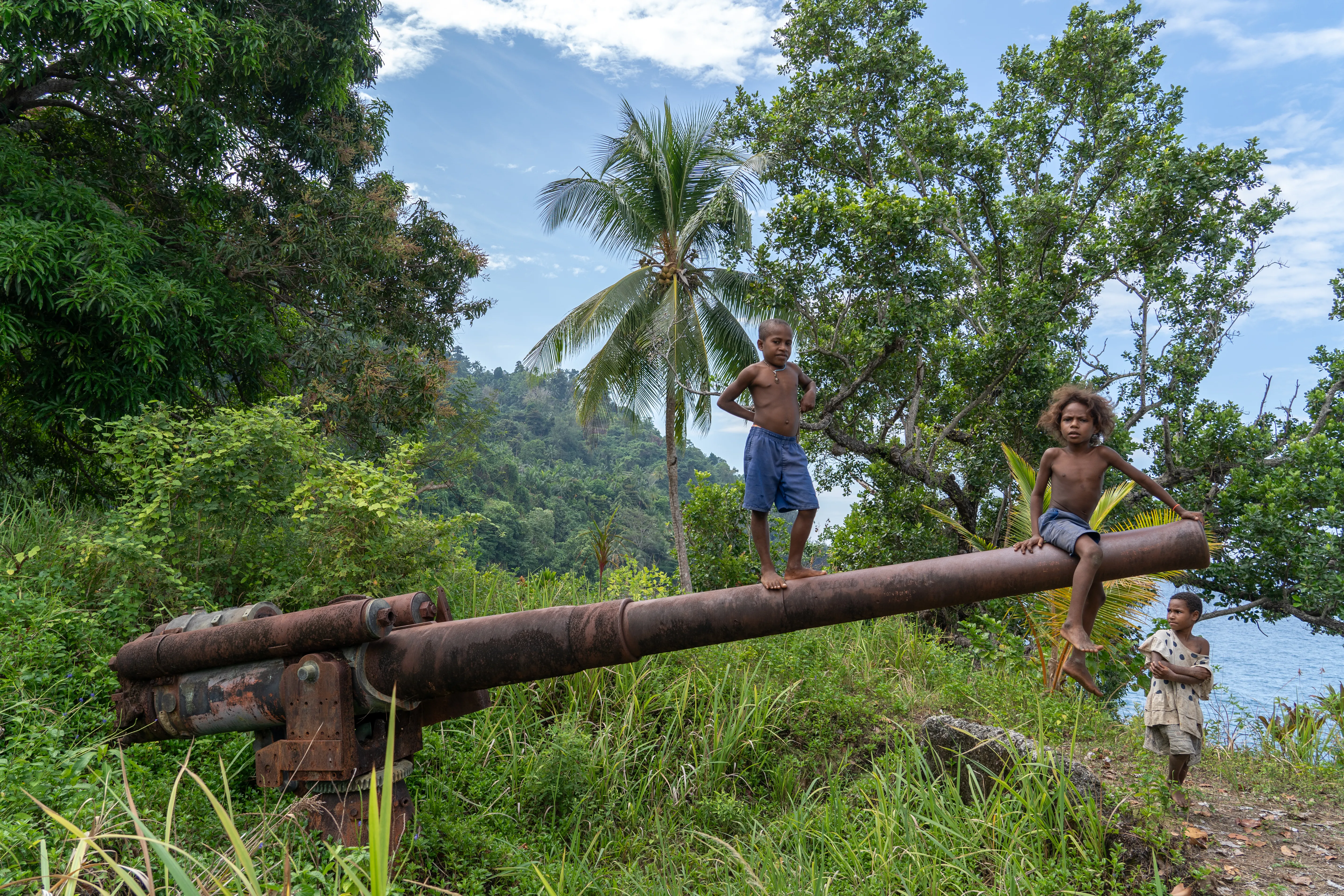 Kids playing on old Japanese WWII relics, Papua New Guinea