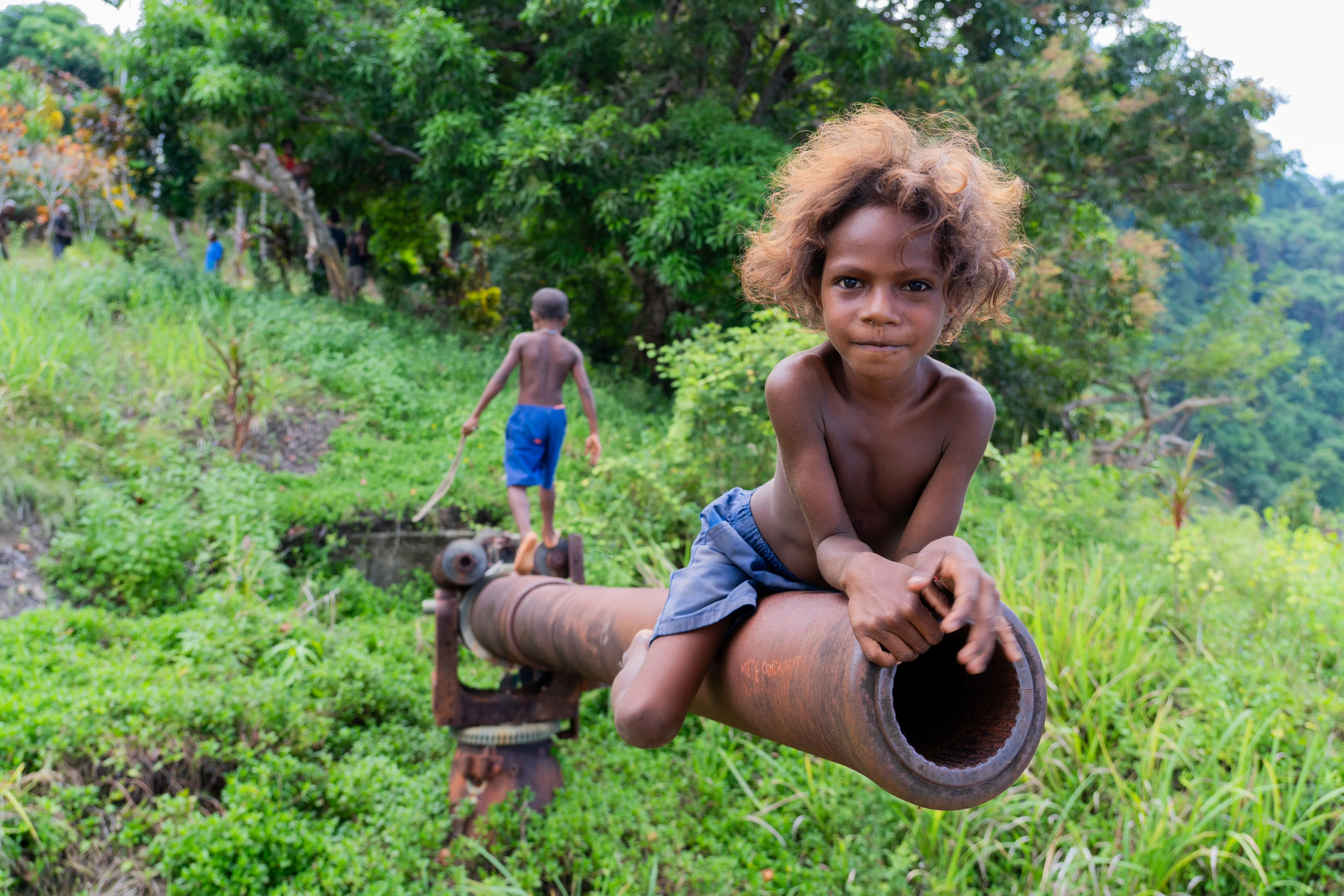 Children playing on an old WWII Japanese artillery gun, Papua New Guinea
