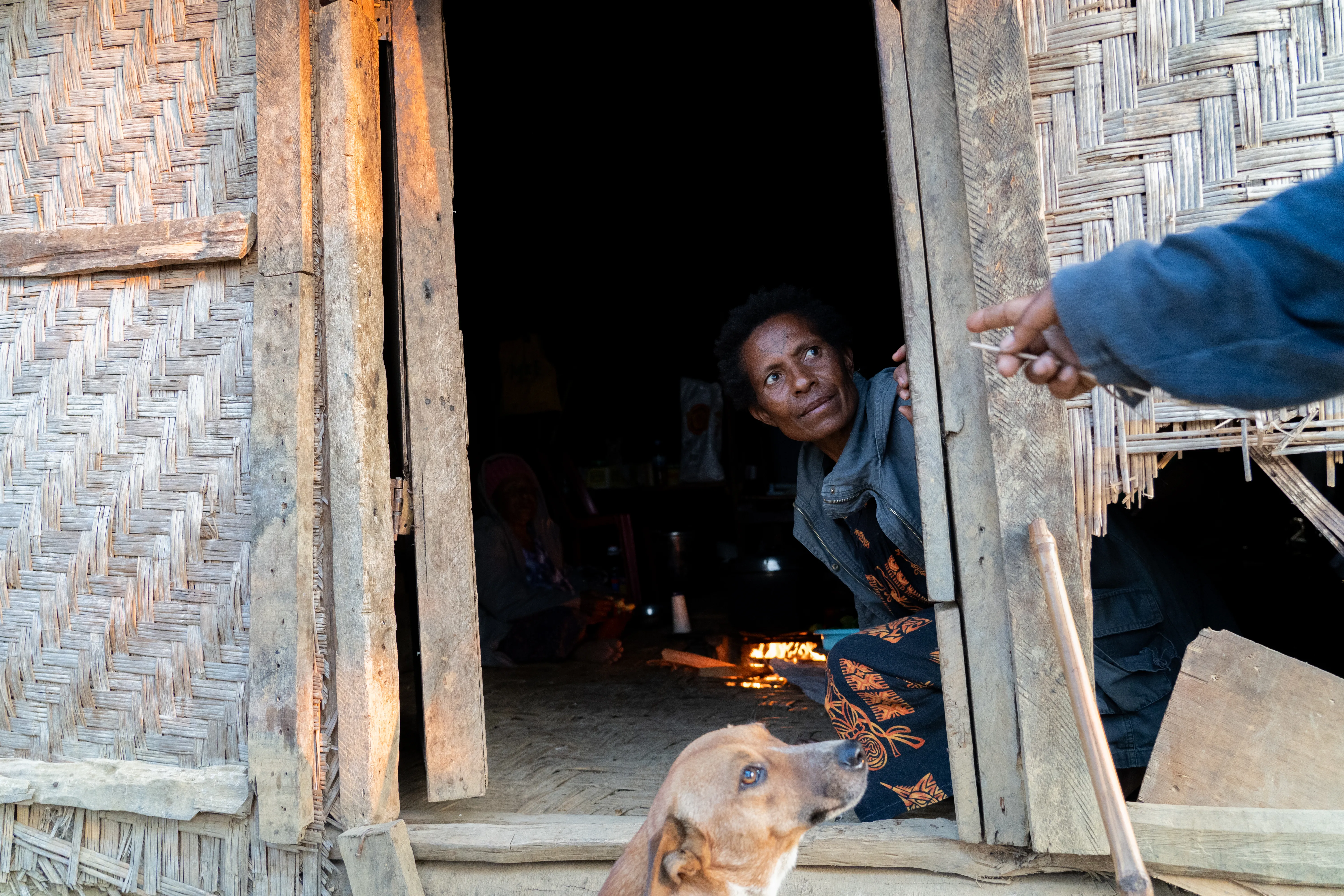 Woman peering through a doorway in the highlands, Papua New Guinea
