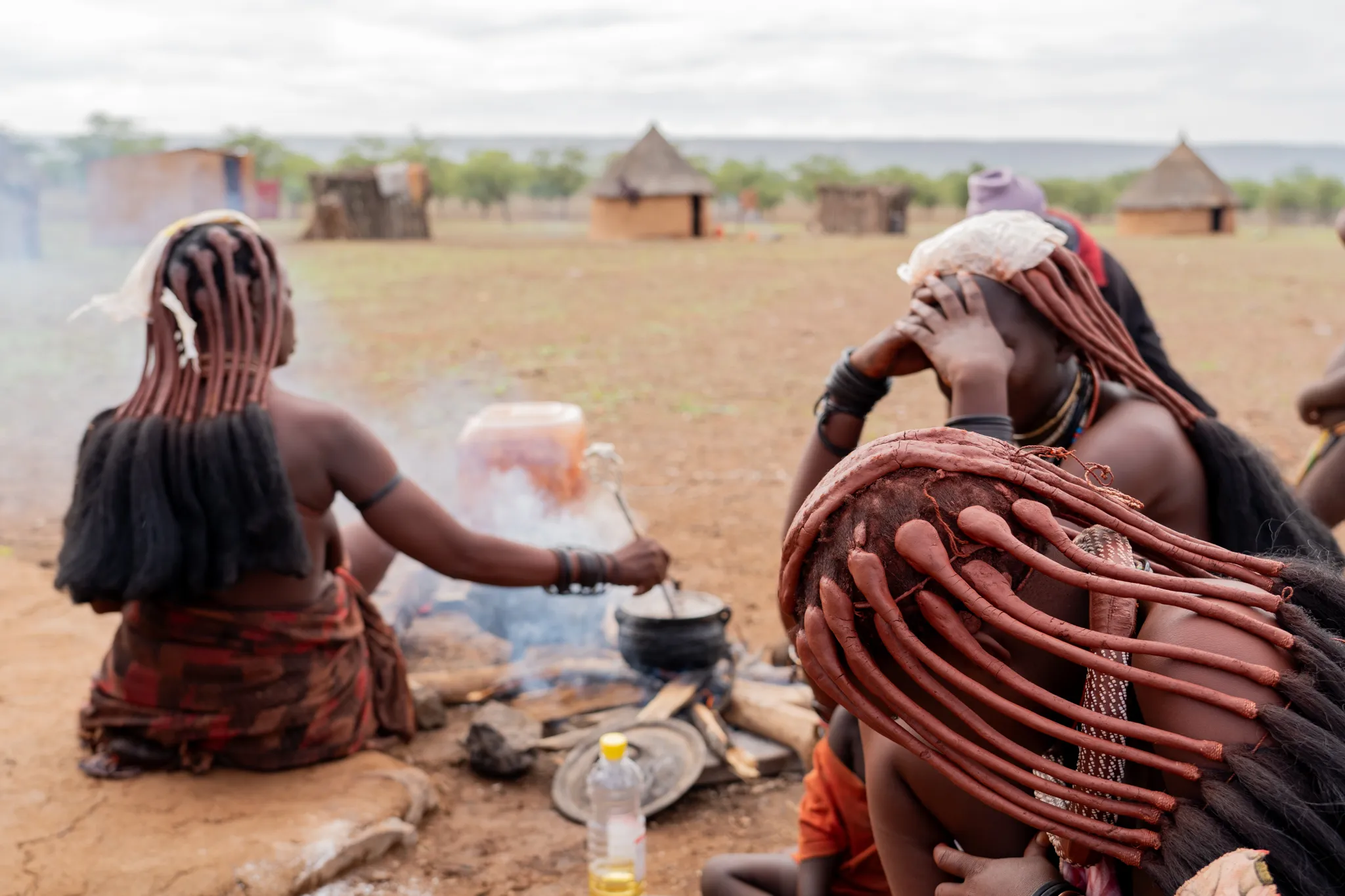 Himba women tending a cooking fire in the village, Namibia